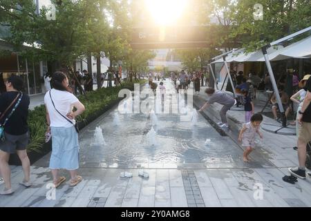 SHANGHAI, CHINA - 1. SEPTEMBER 2024 - Kinder spielen mit Wasser in einem Brunnen, um sich abzukühlen in Shanghai, China, 1. September 2024. Stockfoto