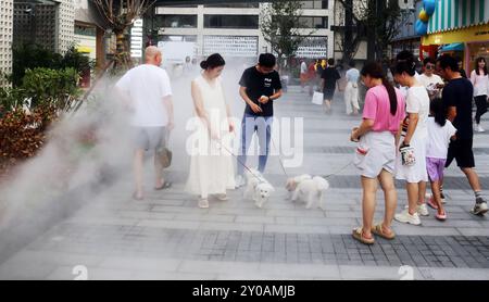 SHANGHAI, CHINA - 1. SEPTEMBER 2024 - Kinder spielen mit Wasser in einem Brunnen, um sich abzukühlen in Shanghai, China, 1. September 2024. Stockfoto