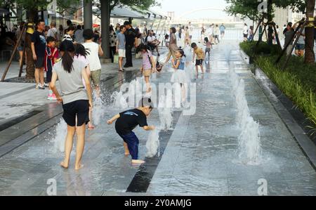 SHANGHAI, CHINA - 1. SEPTEMBER 2024 - Kinder spielen mit Wasser in einem Brunnen, um sich abzukühlen in Shanghai, China, 1. September 2024. Stockfoto