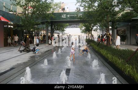 SHANGHAI, CHINA - 1. SEPTEMBER 2024 - Kinder spielen mit Wasser in einem Brunnen, um sich abzukühlen in Shanghai, China, 1. September 2024. Stockfoto