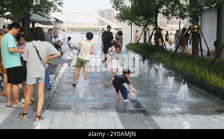 SHANGHAI, CHINA - 1. SEPTEMBER 2024 - Kinder spielen mit Wasser in einem Brunnen, um sich abzukühlen in Shanghai, China, 1. September 2024. Stockfoto