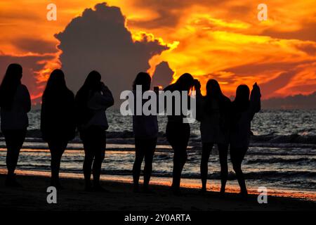 Isle Of Palms, Usa. September 2024. Eine Gruppe junger Frauen, umgeben von der Sonne, versammeln sich am Labor Day Wochenende am 31. August 2024 in Isle of Palms, South Carolina, um den Sonnenaufgang am Strand zu beobachten. Der Labor Day ist traditionell das Ende der Strandferien für die meisten Familien. Quelle: Richard Ellis/Richard Ellis/Alamy Live News Stockfoto