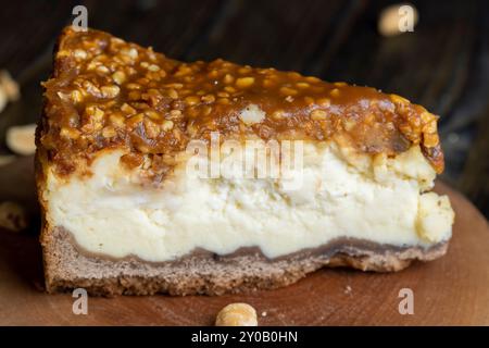 Käsekuchen aus Milchprodukten und Erdnüssen in Karamell, köstliches Dessert mit Erdnüssen, die in Stücke geschnitten werden, um in einem Café Tee zu machen Stockfoto