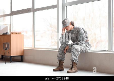 Traurige afroamerikanische Soldatinnen sitzen auf der Fensterbank im Hauptquartier Stockfoto