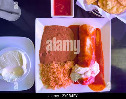 Burrito al Carbon mit Enchilada-Sauce und Sauerrahm Stockfoto