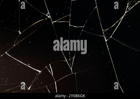 Verschmutztes Glas, das in eine große Anzahl von Teilen zerbrochen ist, ein Stück Glas mit vielen Rissen und gebrochenen Teilen Stockfoto
