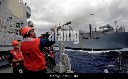 PHILIPPINISCHE SEE (29. August 2024) – Gunner’s Mate 3rd Class Robert Young aus Rockford, Illinois, feuert eine Schusslinie aus dem Forelle an Bord des Arleigh Burke-Klasse-Raketenzerstörers USS Dewey (DDG 105) während einer laufenden Auffüllung mit dem militärischen Sealift Command Lewis und Clark-Klasse Trockenfrachtschiff USNS Richard E. Byrd (T-AKE 4) in der PHILIPPINISCHEN See im Rahmen der Übung 29. August 2024. Commander, Logistics Group Western Pacific/Task Force 73 versorgt stationierte Einheiten im Indopazifik zusammen mit regionalen Verbündeten und Partnern logistisch neu. Pacific Vanguard ist ein Stockfoto