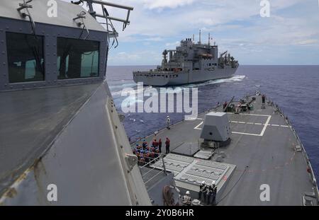 PHILIPPINISCHE SEE (29. August 2024) – der Arleigh-Burke-Klasse-Raketenzerstörer USS Dewey (DDG 105) zieht an der Seite des militärischen Sealift Command Lewis und Clark-Klasse Trockenfrachtschiffs USNS Richard E. Byrd (T-AKE 4), während er während der Übung Pacific Vanguard am 29. August 2024 eine Wiederauffüllung in der Philippinischen See durchführt. Commander, Logistics Group Western Pacific/Task Force 73 versorgt stationierte Einheiten im Indopazifik zusammen mit regionalen Verbündeten und Partnern logistisch neu. Pacific Vanguard ist eine Gelegenheit für gleichgesinnte Kräfte, ihre Fähigkeiten in maritimen Operationen zu stärken, Stockfoto