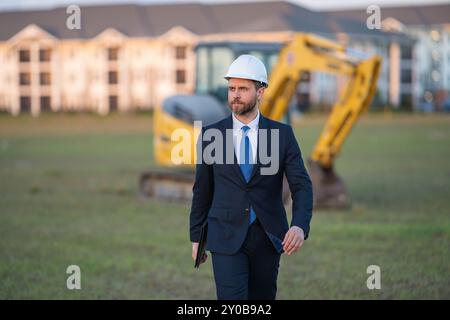 Buider-Mann in Anzug und Schutzhelm. Bauinvestor. Geschäftsmann-Investor vor der Baustelle. Erfolgreicher Investor. Ein hübscher Mann im Anzug Stockfoto