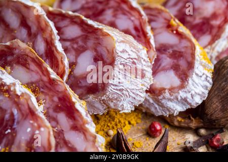 Getrocknete Schweinewurst mit weißem Schimmel und Gewürzen, weißer Schimmel auf trockener Schweinewurst mit verschiedenen Gewürzsorten Stockfoto