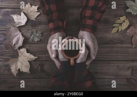 Paar in Liebe Hände halten und trinken Kaffee mit Herbstlaub bedeckt Stockfoto