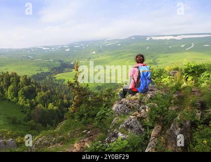 Wanderer mit Rucksack auf einem Berg entspannen und genießen Talblick bei Sonnenaufgang Stockfoto