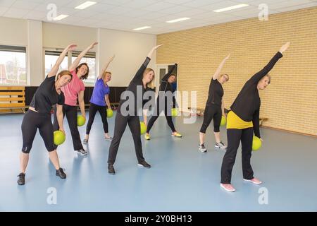 Gruppe von Frauen mit Kugeln zu tun Stretching Übungen im Fitnessstudio Klasse Stockfoto