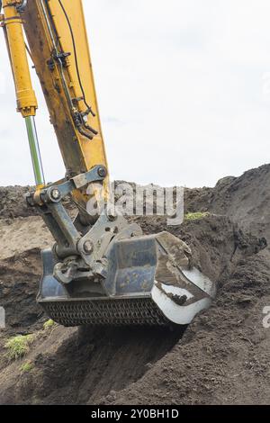 Bagger gräbt, Boden aus sandigen Hügel Stockfoto