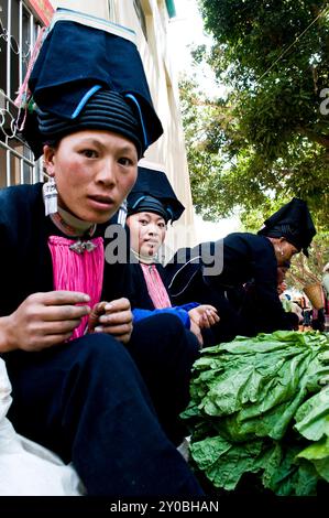 Schwarze Yao Frau auf einem farbenfrohen Wochenmarkt in der südlichen Provinz Yunnan, an der Grenze zu Vietnam, China. Stockfoto