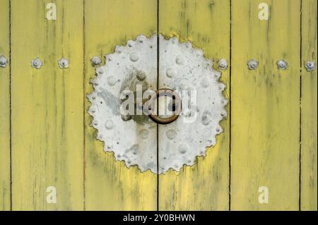 Traditionelle koreanische Eingangstür im „Panmun“-Stil aus Holzpaneelen mit Türgriff aus Eisen. Abgenutzt aussehend, rustikal. Stockfoto