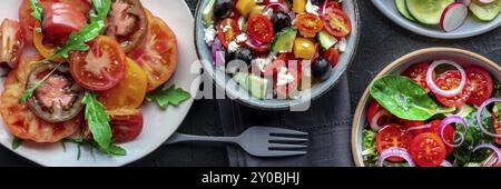 Frische vegetarische Salate Panorama, Overhead Flachbild einer Auswahl. Verschiedene Teller und Schüsseln mit grünem Gemüse. Gesundes Essen, Top Shot Stockfoto
