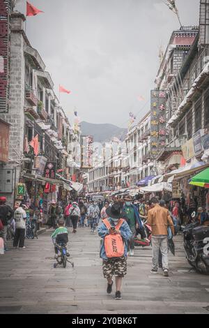 LHASA, TIBET CHINA - 3. JULI 2022: Blick auf eine der Hauptstraßen von Lhasa, in der Nähe der Barkhor Straße und des Jokhang Tempels. Viele Pilger, die herumlaufen, Stockfoto