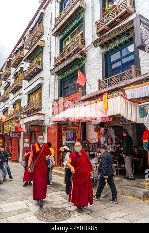 LHASA, TIBET CHINA - 3. JULI 2022: Blick auf eine der Hauptstraßen von Lhasa, in der Nähe der Barkhor Straße und des Jokhang Tempels. Viele Pilger, die herumlaufen, Stockfoto