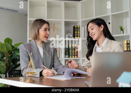 Zwei asiatische Anwältinnen, die einen Vertrag in einem modernen Büro abschließen Stockfoto