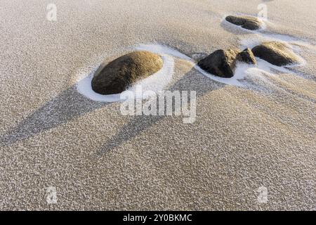 Schneebedeckte Steine an einem Sandstrand, Unstad, Vestvagoy, Lofoten, Nordland, Norwegen, März 2015, Europa Stockfoto