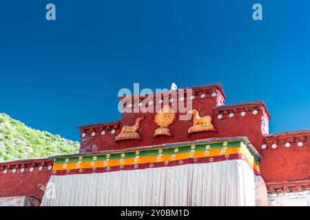 Goldenes Rad des Dharma und Hirschskulpturen auf dem Dach des heiligen Tempels, Tibet, China, Asien Stockfoto