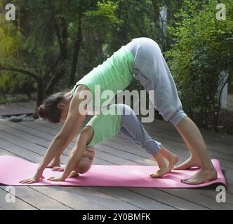 Mutter und Tochter Übung Yoga im Freien zu praktizieren. Gesunde Lebensweise Stockfoto