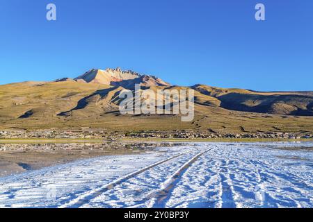 Blick auf den schlafenden Vulkan Tunupa und das Dorf Coqueza am Uyuni Salzsee in Bolivien Stockfoto