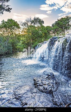 Kleiner Wasserfall und Fluss mit Wasser, das über die Felsen fließt und zwischen den tropischen Wäldern in Carrancas, Minas Gerais, Brasilien, Südamerika liegt Stockfoto