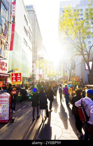 Seoul, Südkorea, 17. April 2015: Touristen gehen die geschäftige, hinterleuchtete Myeongdong Fußgängerzone entlang, mit Kommerzialisierung von Geschäften, Schildern und c Stockfoto