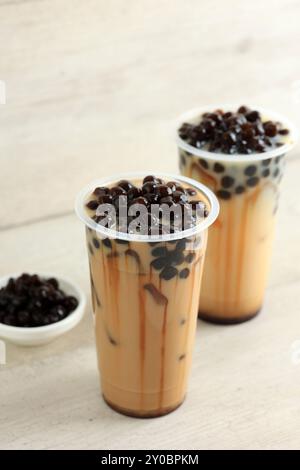 Zwei Glas Taiwan Milk Bubble Tea mit weißem hölzernem Hintergrund. Auf Plastikbecher servieren Stockfoto