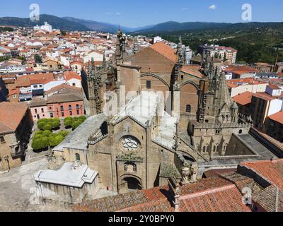 Gotische Kirche mit Türmen und umliegenden Gebäuden mit roten Ziegeldächern an einem sonnigen Tag, Blick aus der Luft, romanische und spätgotische Kathedrale, Plasencia, Stockfoto