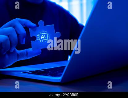 KI-Chip-Symbol auf Puzzleteil gehalten von Geschäftsmanns Hand, die mit Laptop-Computer arbeiten, blauer Hintergrund. Künstliche Intelligenz solutio Stockfoto