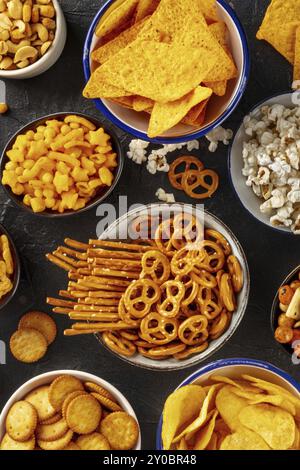 Salzige Snacks, Partymischung, Top Shot. Verschiedene Vorspeisen in Schüsseln. Kartoffel- und Tortilla-Chips, Cracker, Popcorn usw. Stockfoto