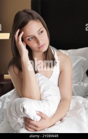 Frau sitzt auf einem Bett aufwachen Stockfoto