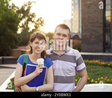 Süße junge schöne Teen paar in der Stadt nahe Universität mit Kaffee nach dem Studium und Spaß zusammen lachen und Lächeln Stockfoto