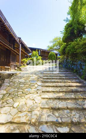 Mit Intarsien aus Stein Straße neben japanischen Stil, traditionelle Holzhäuser in Tsumago Dorf auf dem historischen Nakasendo Route in Japan. Vertikale Stockfoto