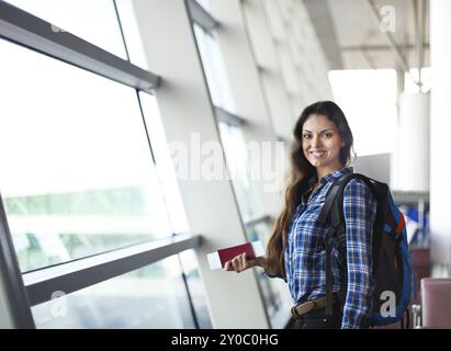 Hübsche junge Passagierin am Flughafen (flaches Freiheitsgrad, farbiges Bild) Stockfoto