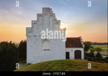 Die berühmte Kirche Elmelunde auf der Insel Moen in Dänemark. Die Kirche ist berühmt für ihre mittelalterlichen Fresken. Es gibt einen bronzezeitlichen Grabhügel Stockfoto