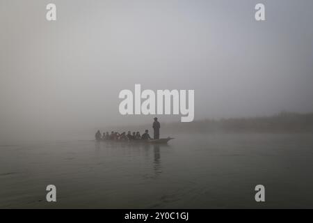 Chitwan National Park, Nepal, 30. November 2014: Kanu mit Touristen auf einem Fluss im Morgennebel, Asien Stockfoto