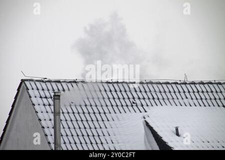 Haus mit Schnee und Rauchschornstein Stockfoto