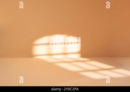 Abstrakter beigefarbener Raumhintergrund mit Sonnenlichtspuren, Hintergrund mit Schatten eines Fensters für Produktpräsentation defokussiertes Papier Stockfoto