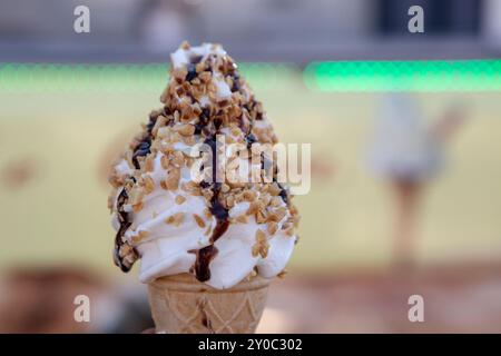 Eisbecher mit Vanille, Schokolade und Erdnusskrümeln, weichem Fokus Stockfoto