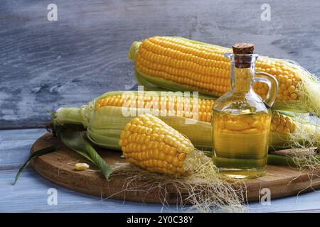 Frischer Mais mit Flasche Öl auf Holz Hintergrund Stockfoto
