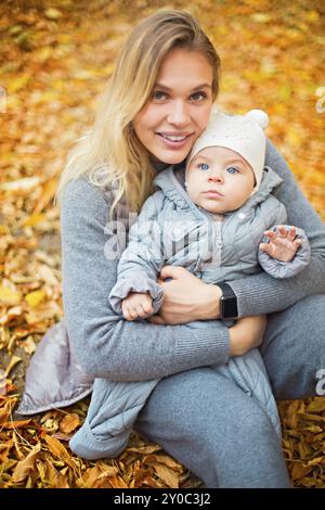 Happy Family im Freien. Mutter und ihre kleine Tochter spielen, kuscheln sich Herbst Spaziergang in der Natur im Freien Stockfoto