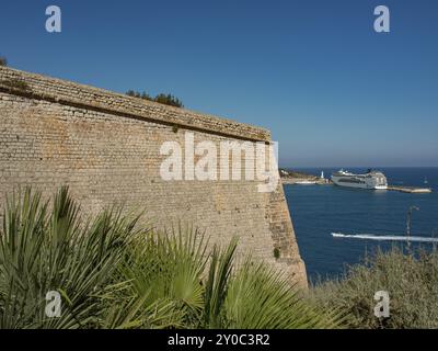 Historische Festungsmauer mit Blick auf das Meer und ein vorbeifahrendes Kreuzfahrtschiff, ibiza, mittelmeer, spanien Stockfoto