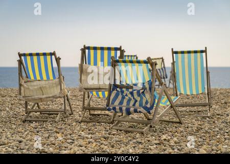 Leere Liegestühle mit Meerblick an einem Kiesstrand Stockfoto