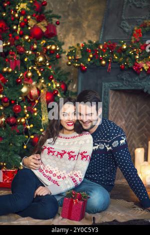 Mann umarmt glücklich Freundin mit Weihnachten am Weihnachtsabend vorhanden Stockfoto