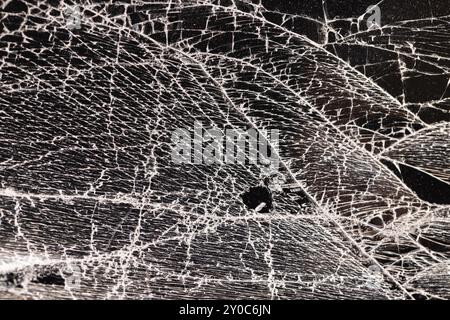 Verschmutztes Glas, das in eine große Anzahl von Teilen zerbrochen ist, ein Stück Glas mit vielen Rissen und gebrochenen Teilen Stockfoto