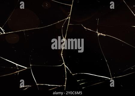 Verschmutztes Glas, das in eine große Anzahl von Teilen zerbrochen ist, ein Stück Glas mit vielen Rissen und gebrochenen Teilen Stockfoto